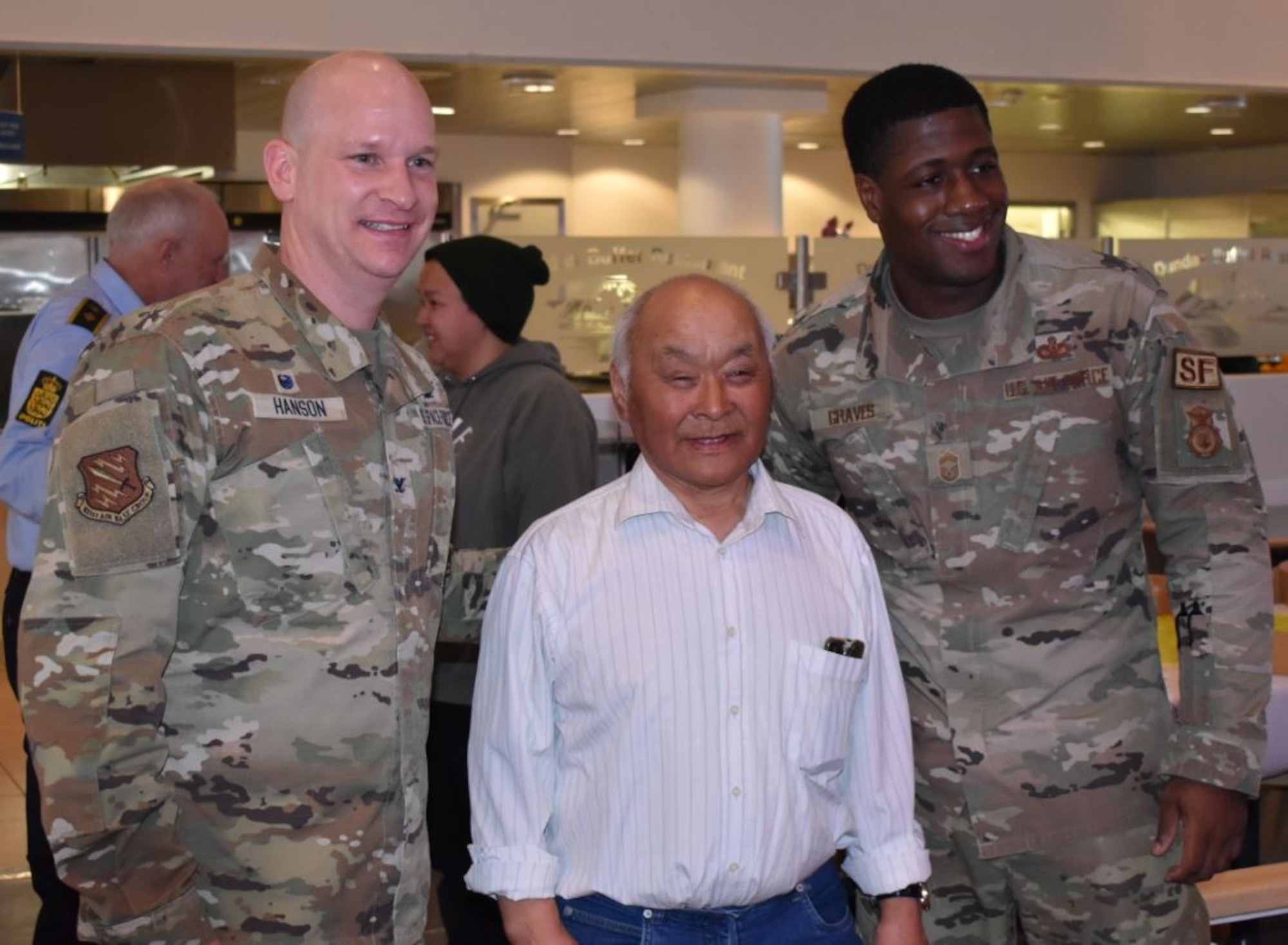 Qaerngaq Nielsen, a winner of the Greenlandic Heritage Week dogsled race, poses with U.S. Air Force Col. David Hanson, left, 821st Air Base Group commander and U.S. Air Force Chief Master Sgt. Micah Graves, right, 821st Security Forces Squadron chief enlisted manager, at the Dundas Dining Facility, Thule Air Base, Greenland, April 4, 2021. Nielsen, who lives in Savissivik, Greenland, has been attending Greenlandic Heritage Week for nearly 40 years and has won the dogsled race eight times.  (U.S. Space Force photo by Lt. Col. Christopher Ivarone)