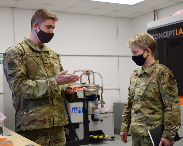 Maj. Ryan Kemnitz, assistant professor of astronautical engineering, describes AFIT’s additive manufacturing 3D printer process to Brig. Gen. Linell Letendre, dean of faculty, USAFA.  The state-of-the-art system uses a laser to melt a finely graded metal powder, layer by layer, to digitally fabricate aerospace metal parts.