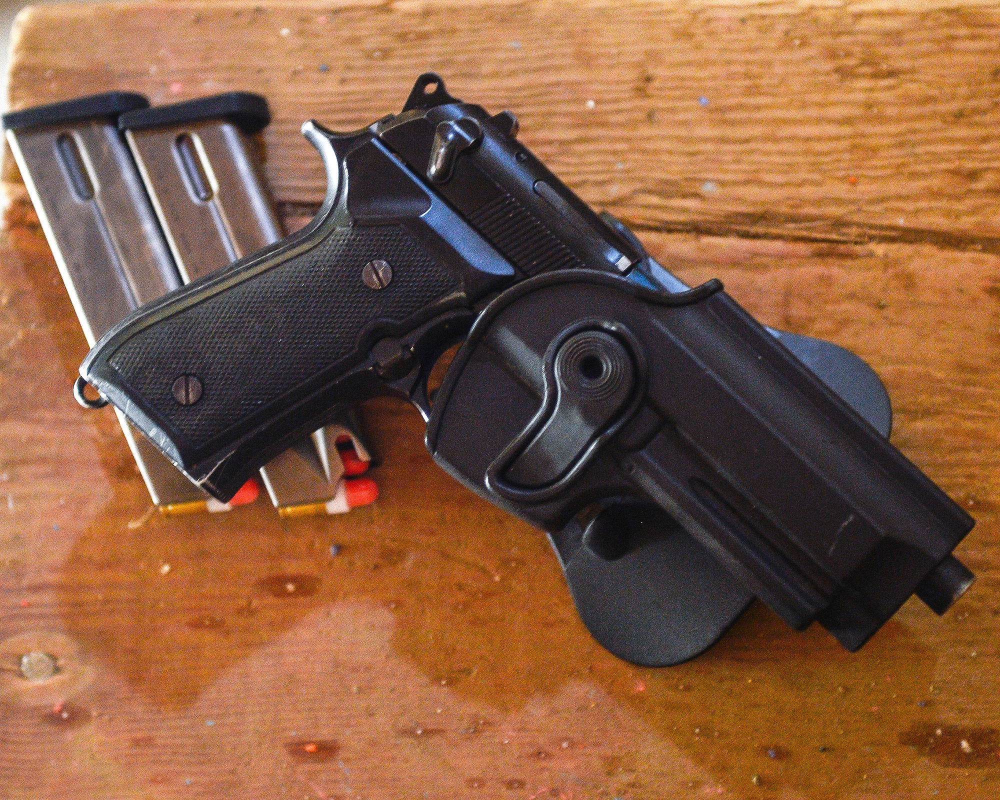 An unloaded M9 Berretta and magazines filled with simulatin rounds rests on the stairs.