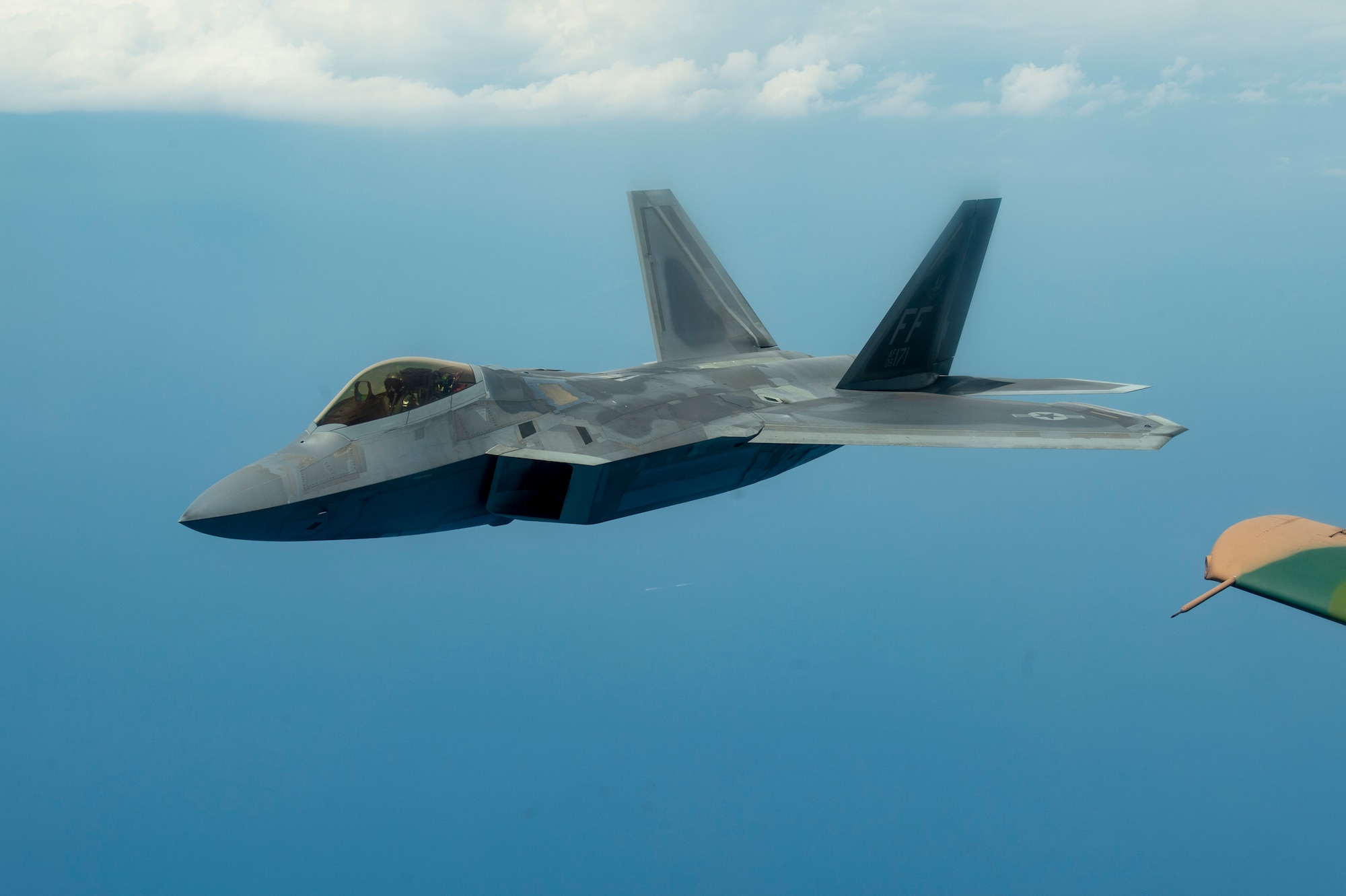 An F-22 Raptor aircraft flies through the air after being refueled by a KC-135 Stratotanker aircraft from MacDill Air Force Base, Fla., April 18, 2021. The F-22 performed during the SUN ‘n FUN Aerospace Expo earlier that day, alongside the A-10 Thunderbolt II aircraft and the P-51 Mustang aircraft. (U.S. Air Force photo by Airman 1st Class David D. McLoney)