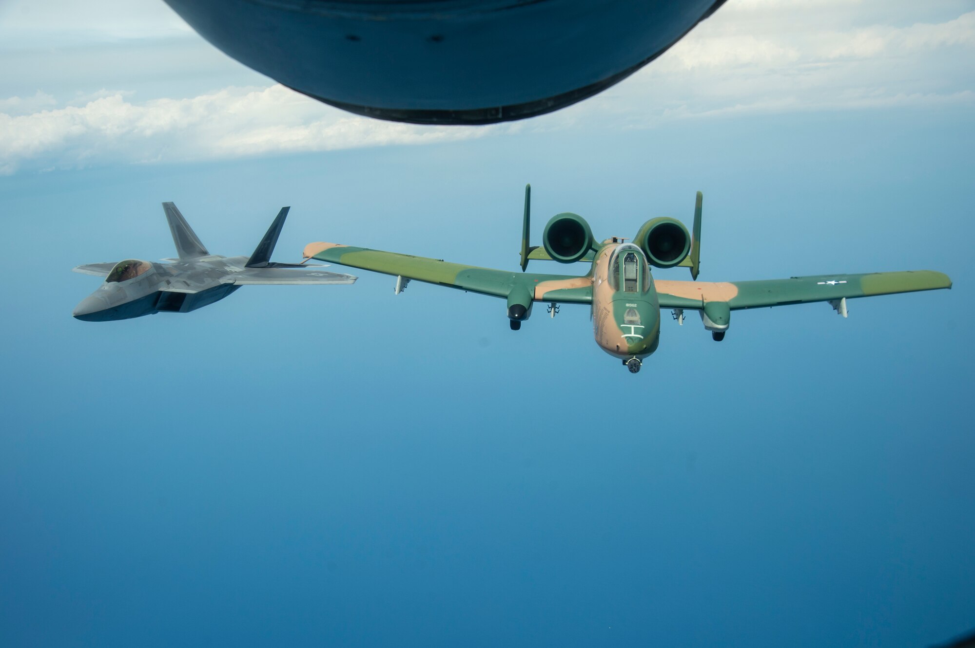 An F-22 Raptor aircraft and an A-10 Thunderbolt II aircraft fly through the air after being refueled by a KC-135 Stratotanker from MacDill Air Force Base, Fla., April 18, 2021. The F-22 and the A-10 were two of many aircraft that participated in both the SUN ‘n FUN Aerospace Expo located in Lakeland, Fla., and the Cocoa Beach Air Show located in Cocoa Beach, Fla. (U.S. Air Force photo by Airman 1st Class David D. McLoney)