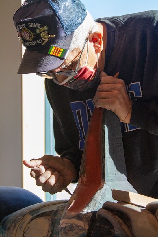 George Bennett restores the 11.5-foot honor pole that sits in front of the Alaska National Guard armory April 17, 2021, on Joint Base Elmendorf-Richardson after 12 years since originally carving it with his son. The pole was originally built in Sitka and serves as a monument dedicated to the profound contributions of the Alaska Natives to the safety and heritage of the state in the past and present. (U.S. Army National Guard photo by Spc. Grace Nechanicky)