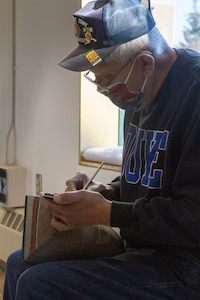 George Bennett restores the 11.5-foot honor pole that sits in front of the Alaska National Guard armory April 17, 2021, on Joint Base Elmendorf-Richardson after 12 years since originally carving it with his son. The pole was originally built in Sitka and serves as a monument dedicated to the profound contributions of the Alaska Natives to the safety and heritage of the state in the past and present. (U.S. Army National Guard photo by Spc. Grace Nechanicky)