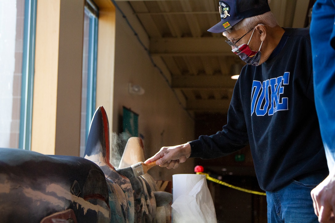 George Bennett restores the 11.5-foot honor pole that sits in front of the Alaska National Guard armory April 17, 2021, on Joint Base Elmendorf-Richardson after 12 years since originally carving it with his son. The pole was originally built in Sitka and serves as a monument dedicated to the profound contributions of the Alaska Natives to the safety and heritage of the state in the past and present. (U.S. Army National Guard photo by Spc. Grace Nechanicky)