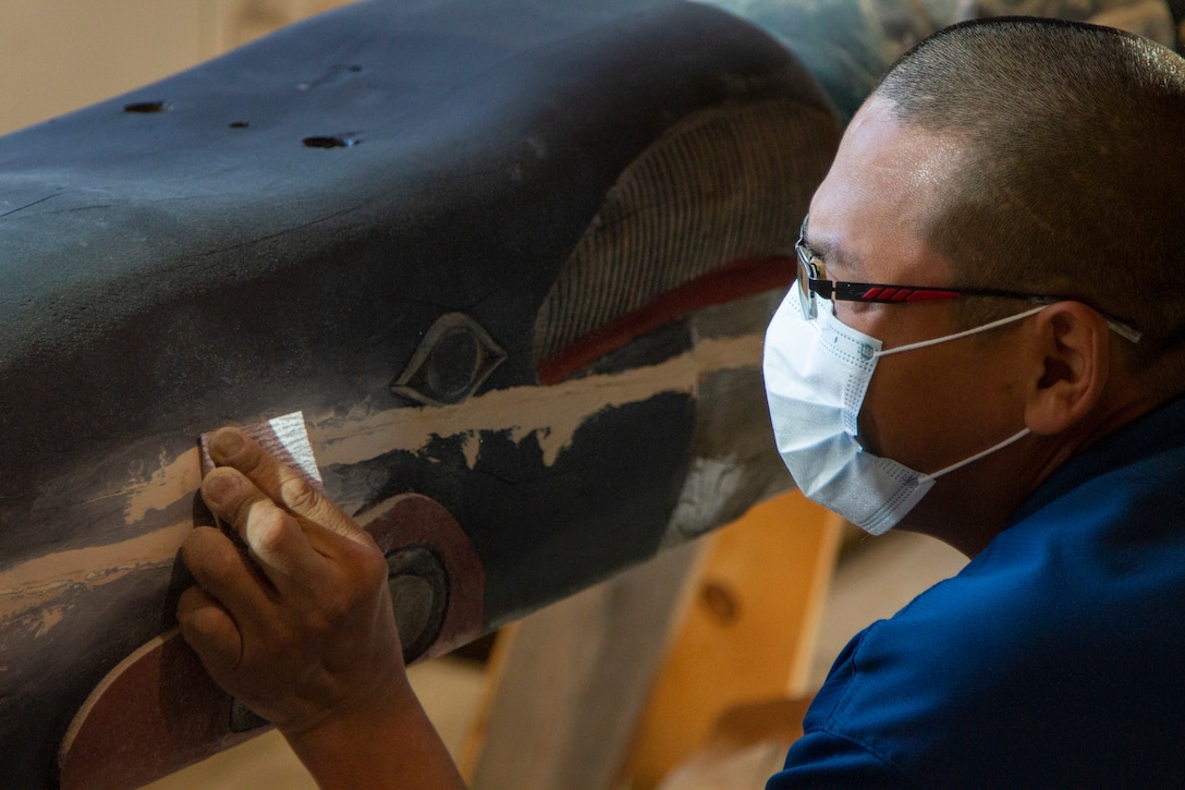 James Bennett restores the 11.5-foot honor pole that sits in front of the Alaska National Guard armory April 17, 2021, on Joint Base Elmendorf-Richardson after 12 years since originally carving it with his father. The pole was originally built in Sitka and serves as a monument dedicated to the profound contributions of the Alaska Natives to the safety and heritage of the state in the past and present. (U.S. Army National Guard photo by Spc. Grace Nechanicky)