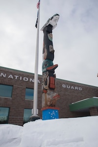 The honor pole that was built by George and James Bennett, a father-son duo from Sitka, sits in front of the Alaska Army National Guard armory April 1, 2021, days before it is restored. The pole is a momument that was built in 2007 and 2008, and is dedicated to the profound contributions of the Alaska Natives to the safety and heritage of the state in the past and present. (U.S. Army National Guard photo by Spc. Grace Nechanicky)