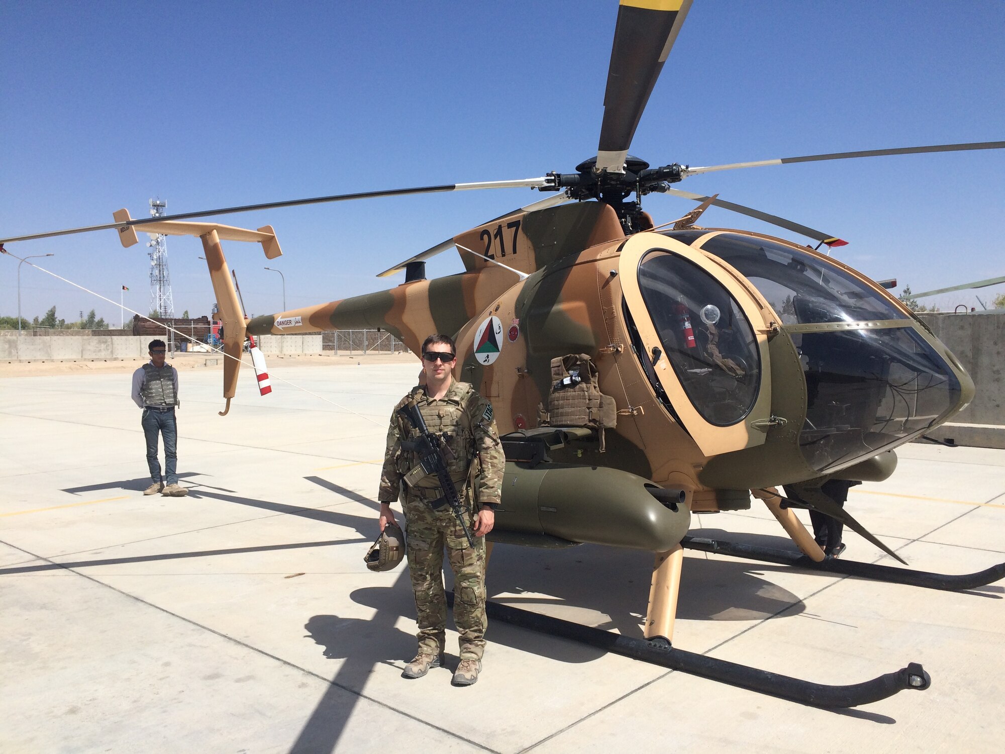 Photo of an Airman in front of a helicopter.