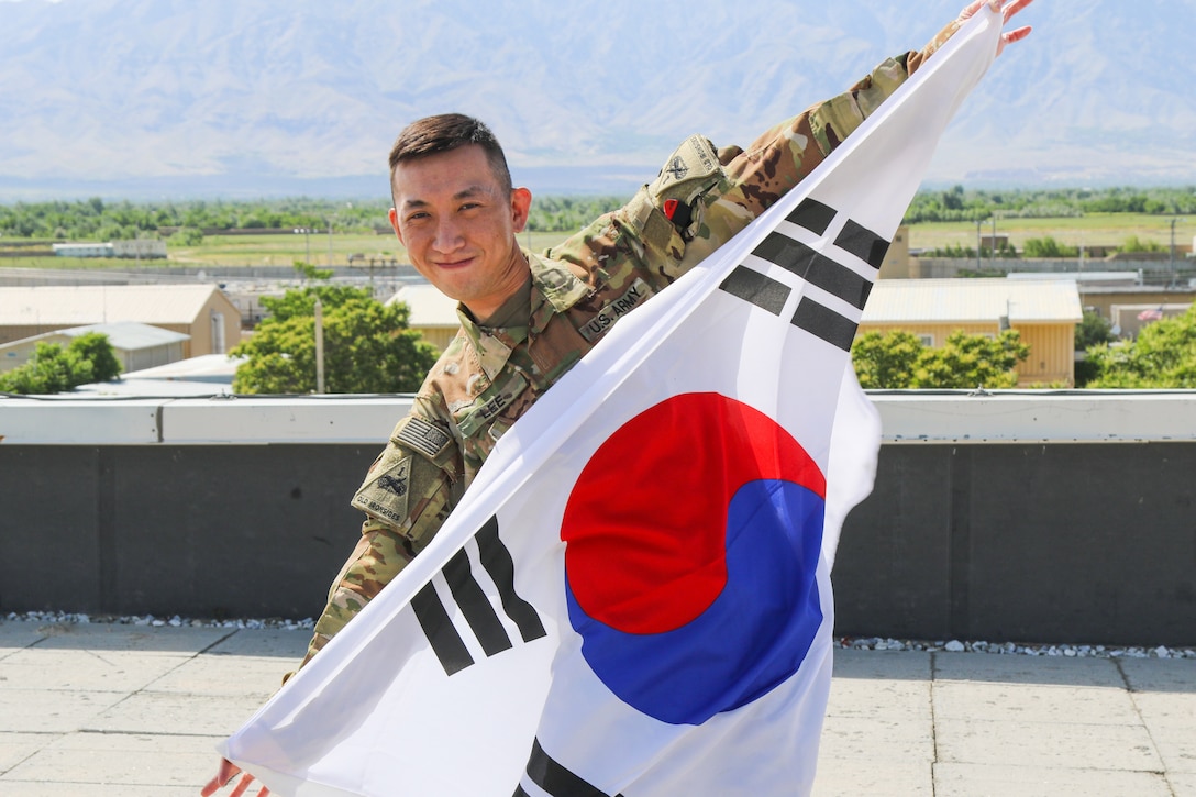 A soldier holds up a South Korean flag.