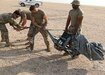 Riggers of the Fort Bragg, North Carolina, based 151st Quartermaster Company, deployed the U.S. Central Command area of responsibility in support of 1st Theater Sustainment Command, work to recover one of four Joint Precision Air Delivery System, or JPADS, units used to air drop four bundles  at the Camp Buehring, Kuwait, drop zone. The black device rigged between the parafoil and the payload is the Modular Autonomous Guidance Unit, or MAGU, which uses the lines of the chute to steer it to its programmed target.