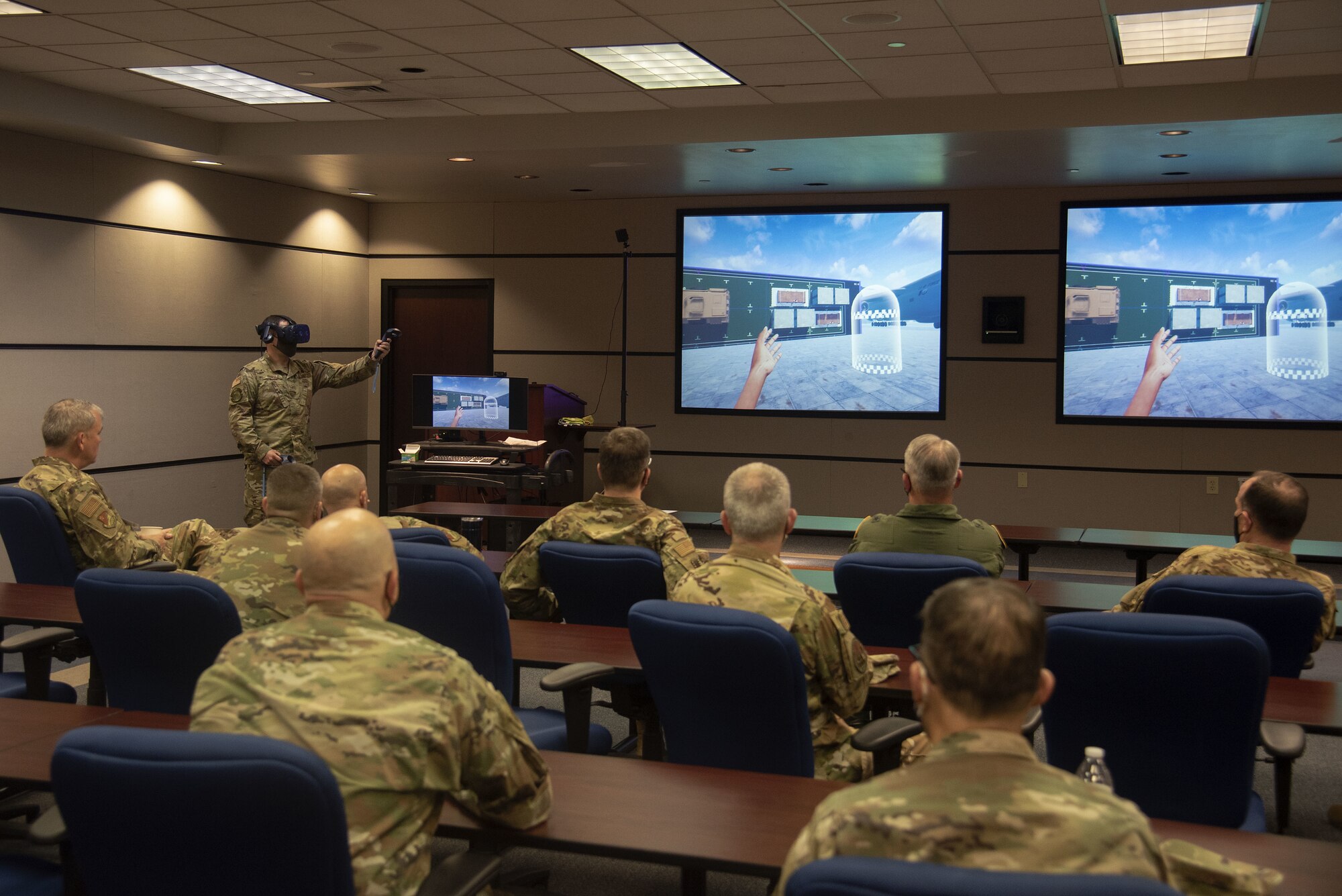 U.S. Air Force Staff Sgt. Matthew Reinitz, 423rd Mobility Training Squadron Aerial Port Expeditor instructor, explains how aerial porters utilize simulators for training to Total Force Mobility Air Forces (TF MAF) leadership during Total Force Phoenix Rally, April 21, 2021, at the U.S. Air Force Expeditionary Center headquarters on Joint Base McGuire-Dix-Lakehurst, New Jersey. U.S. Air Force Expeditionary Operations School instructors were given the opportunity to showcase their contributions to leadership throughout TF MAF. (U.S. Air Force photo by Master Sgt. Ashley Hyatt)