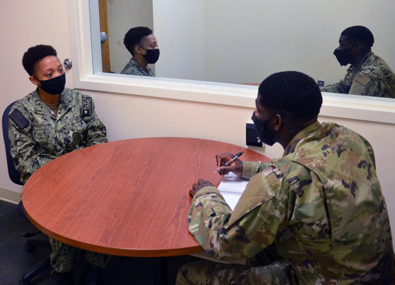 Airman Frederick Hall, (right) an Air Force student in the METC Behavioral Health Technician program, conducts a mock counseling session with Seaman Chery Gonzales-Polanco, (left), a Navy student acting as a patient in the simulation.