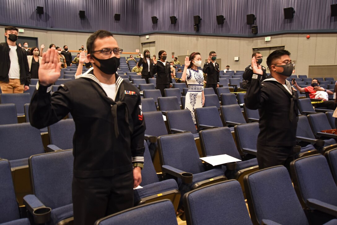 Sailors and civilians at Commander, Fleet Activities Yokosuka (CFAY) recite the oath of allegiance during a United States Citizenship and Immigration Services (USCIS) naturalization ceremony.