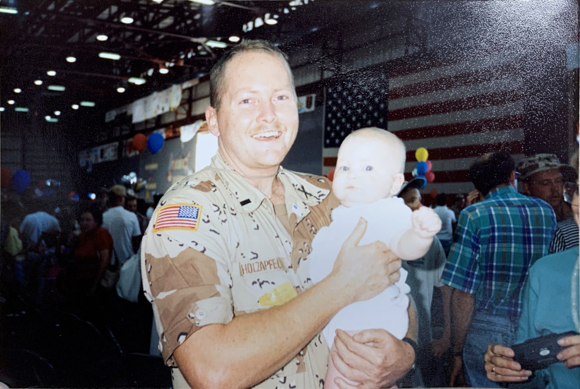 Army 1st Lt. John Holzapfel, holds his -- then 10-month-old -- daughter, Staff Sgt. Ryann Holzapfel, 374th Airlift Wing craftsman, after he returned home from a year-long deployment for Operation Desert Storm in Omaha, Nebraska 1991.