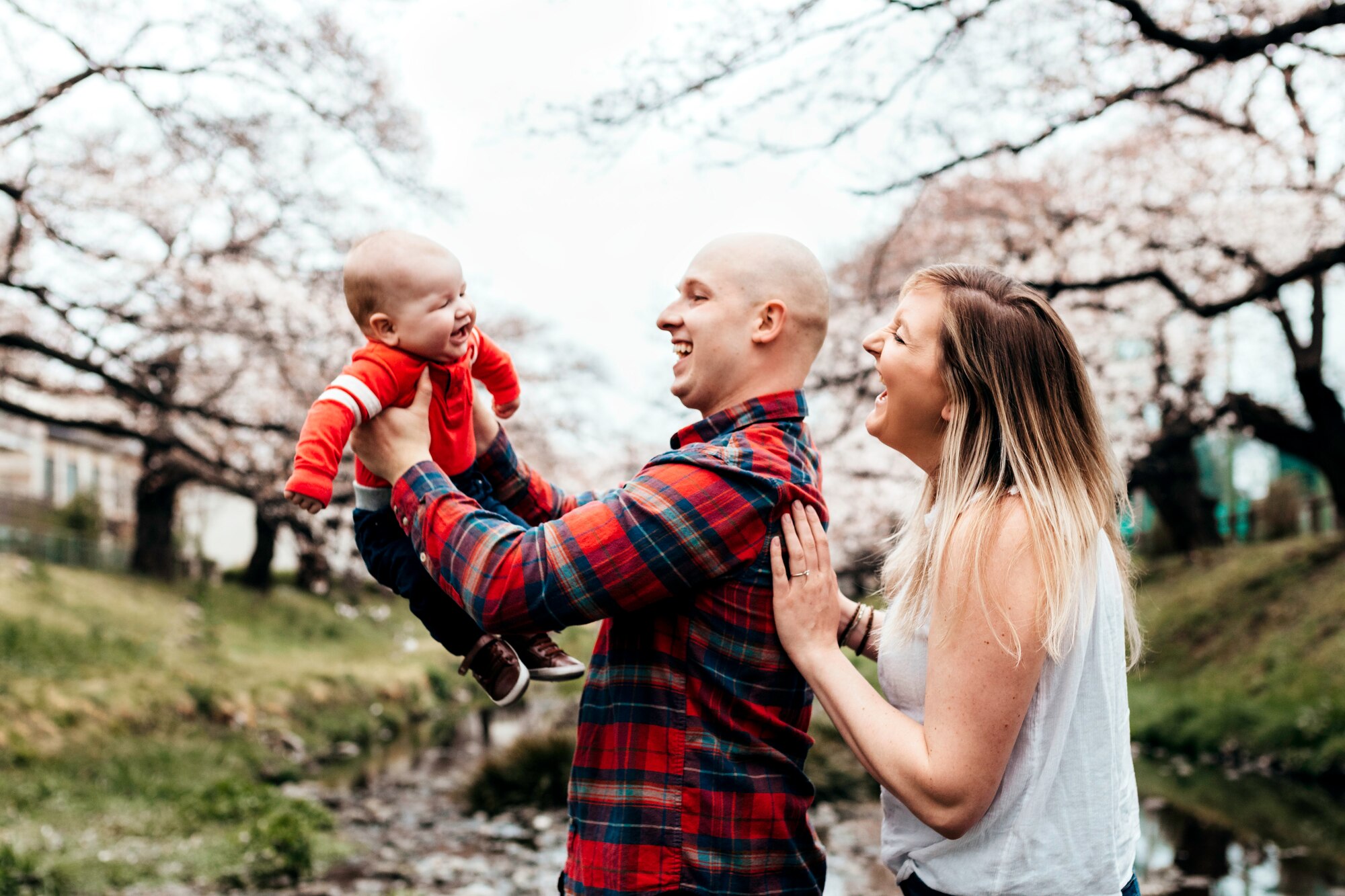 Staff Sgt. Ryann Holzapfel, 374th Airlift Wing Public Affairs craftsman, right, and her husband Staff Sgt. Brendan Miller, Armed Forces Network Tokyo broadcaster, pose for a family photo in Tachikawa, Japan, March 26, 2021.