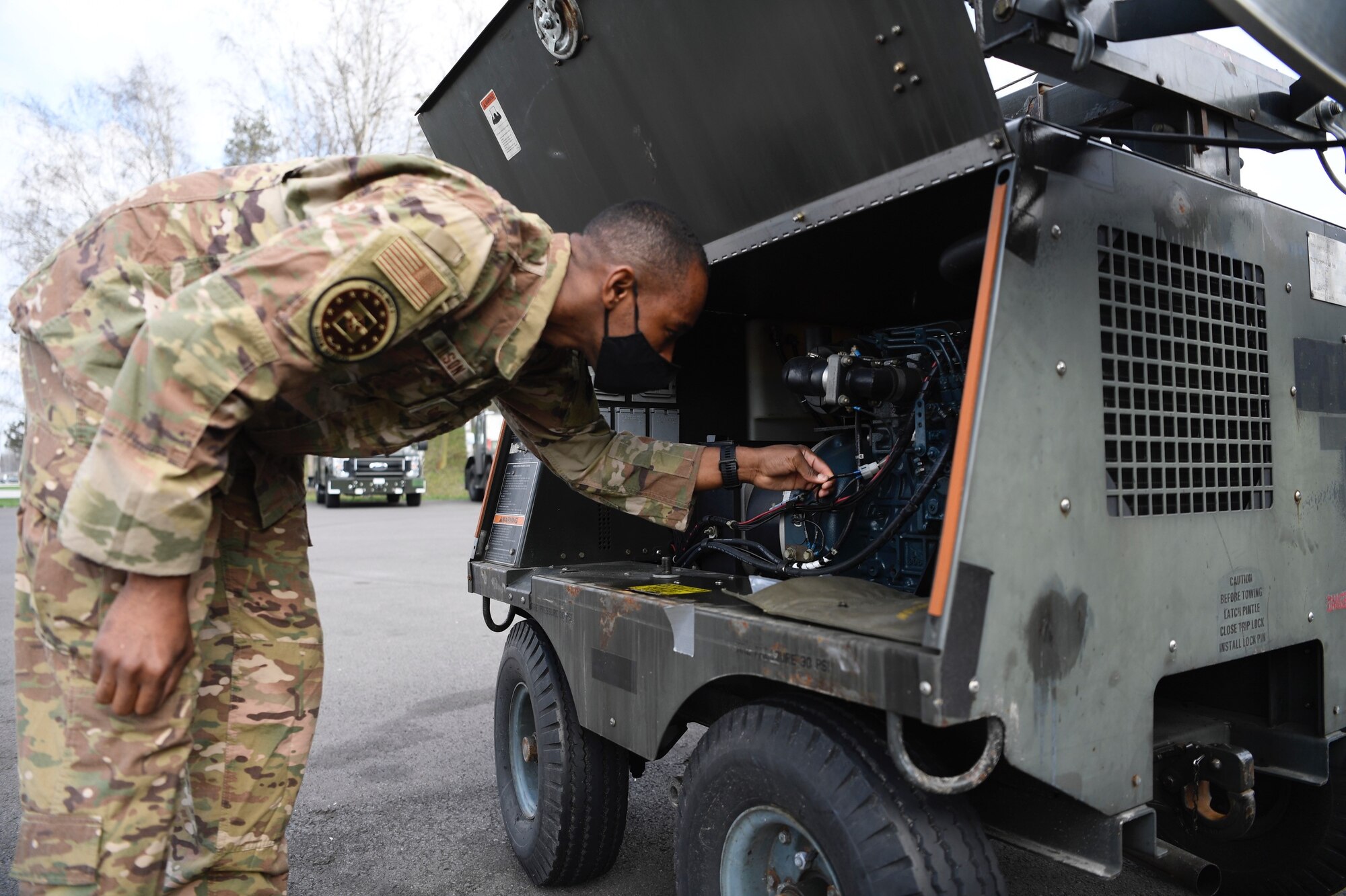 U.S. Air Force Tech. Sgt. John Wilson, 52nd Operations Group Detachment 1 maintenance support liaison, inspects a floodlight at Łask Air Base, Poland, April 21, 2021. Wilson, the subject matter expert for all the aerospace ground equipment in Poland, also helps with any maintenance issues and inspections. (U.S. Air Force photo by Tech. Sgt. Warren D. Spearman Jr.)