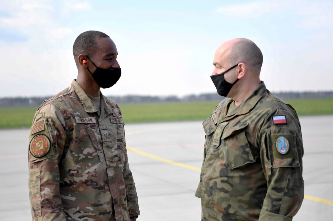 U.S. Air Force Tech. Sgt. John Wilson, 52nd Operations Group Detachment 1 maintenance support liason, chats with Polish Air Force Maj. Wojciech Adamczyk, 32nd Air Base flight safety inspector, at Łask Air Base, Poland, April 21, 2021. Some of Wilson’s duties include working with the Polish Air Force to resolve maintenance issues and conduct inspections. (U.S. Air Force photo by Tech. Sgt. Warren D. Spearman Jr.)
