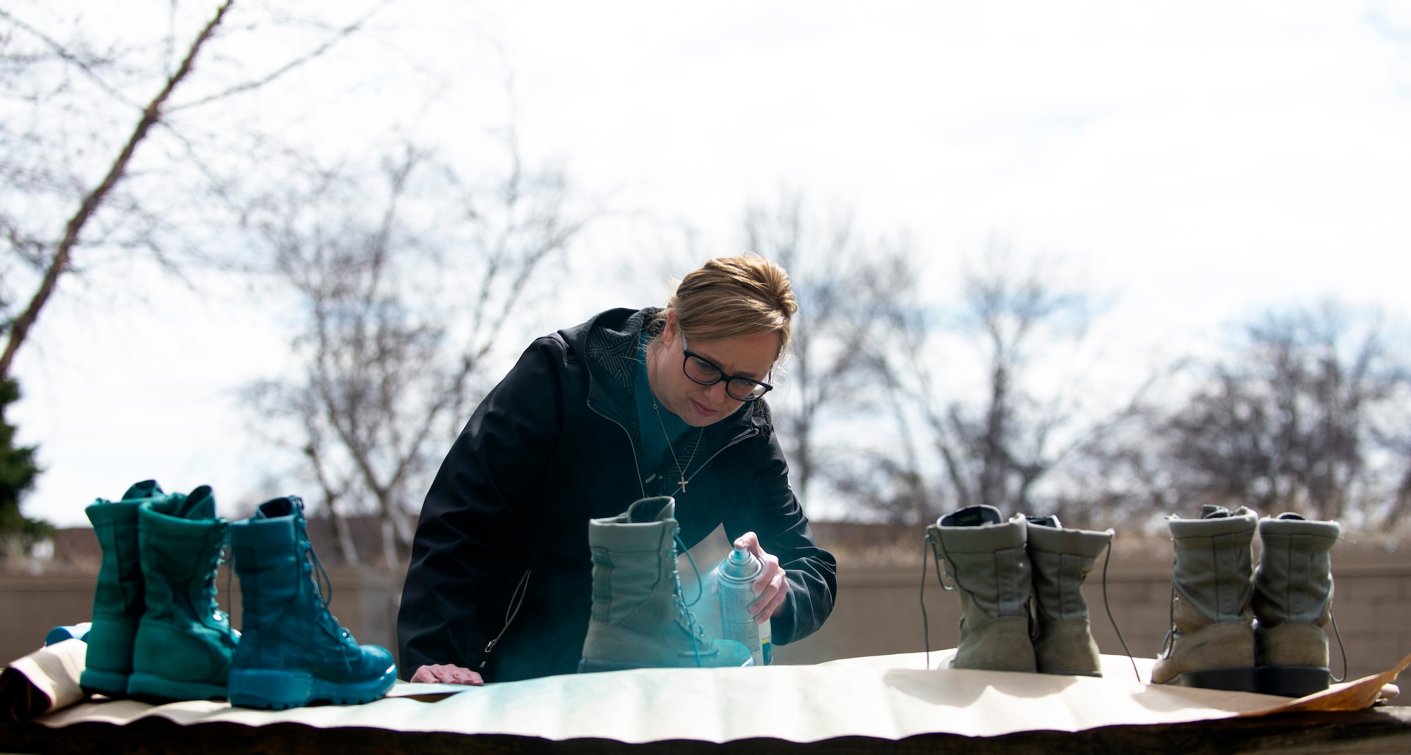 Krista Sheridan, 133rd Sexual Assault Response Coordinator, paints combat boots teal in St. Paul, Minn., Mar. 31, 2021.