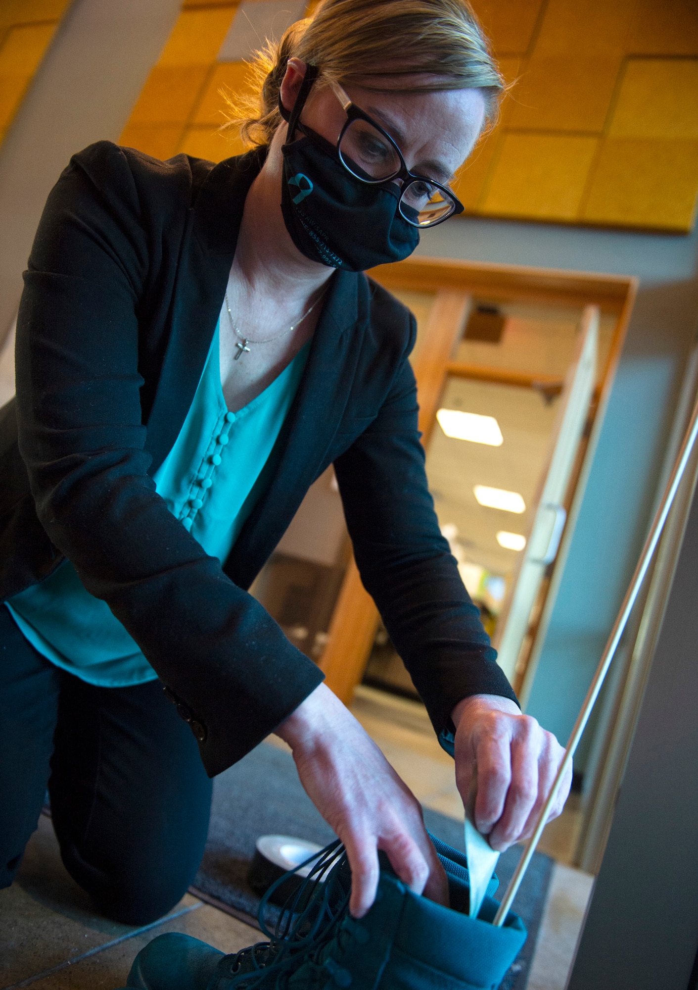 Krista Sheridan, 133rd Sexual Assault Response Coordinator, places a pair of teal combat boots in a hallway in St. Paul, Minn., Mar. 31, 2021.