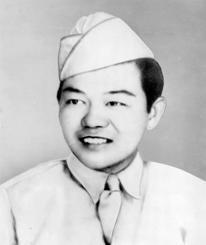 A man in uniform and cap smiles.