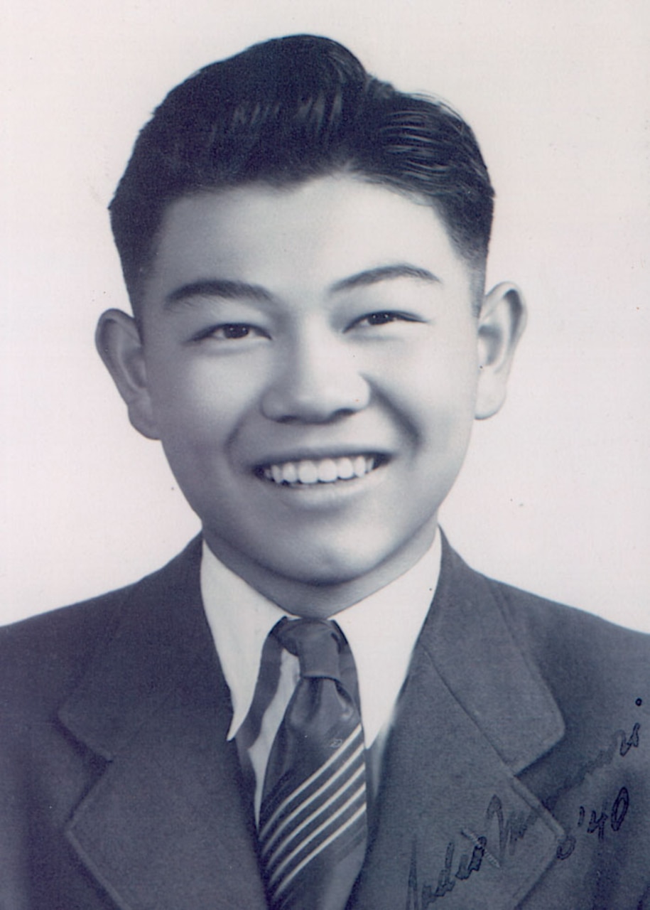 A man in a suit smiles.