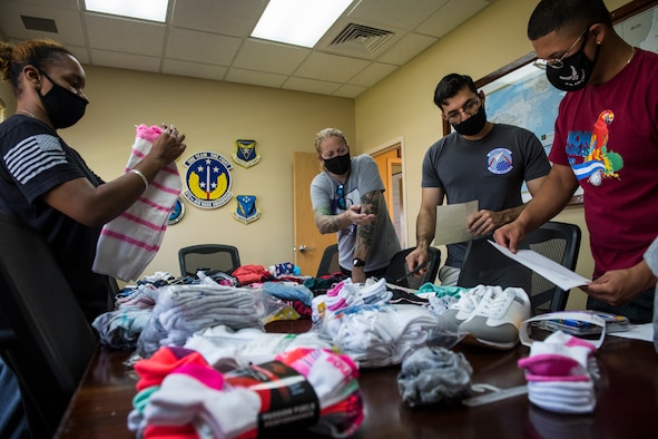 U.S. Airmen with the 612th Air Base Squadron, prepare donations for children at the Children of Love Foundation in La Paz, Honduras, at Soto Cano Air Base, Honduras, April 24, 2021. Members with the 612th ABS donated clothing, shoes, underwear, and towels in a backpack for each child, as well as toys, soap, toothpaste, and school supplies that were delivered in large boxes to 18 orphans who live at the orphanage. (U.S. Air Force photo by Tech. Sgt. Marleah Cabano)