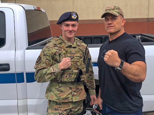 Man in Air Force duty uniform stands next to posses with John Gretton “Jocko” Willink.