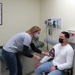 Kelli Ranalli, a Registered Nurse with U.S. Army Health Clinic Vicenza, checks the blood pressure of a patient.