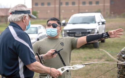 Steve Arnold, volunteer archer coach, discusses sight settings with U.S. Marine Cpl. Joseph Quintanilla as part of the Wounded Warrior archery competition practice and bow fitting at Joint Base San Antonio-Fort Sam Houston April 5.
