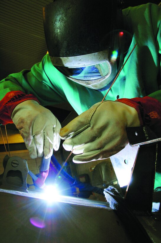 A welder works on a military vehicle