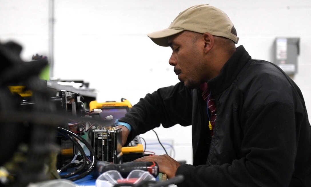 A technician works on a robotic machine at Marine Depot Maintenance Command, Production Plant Albany, Georgia.