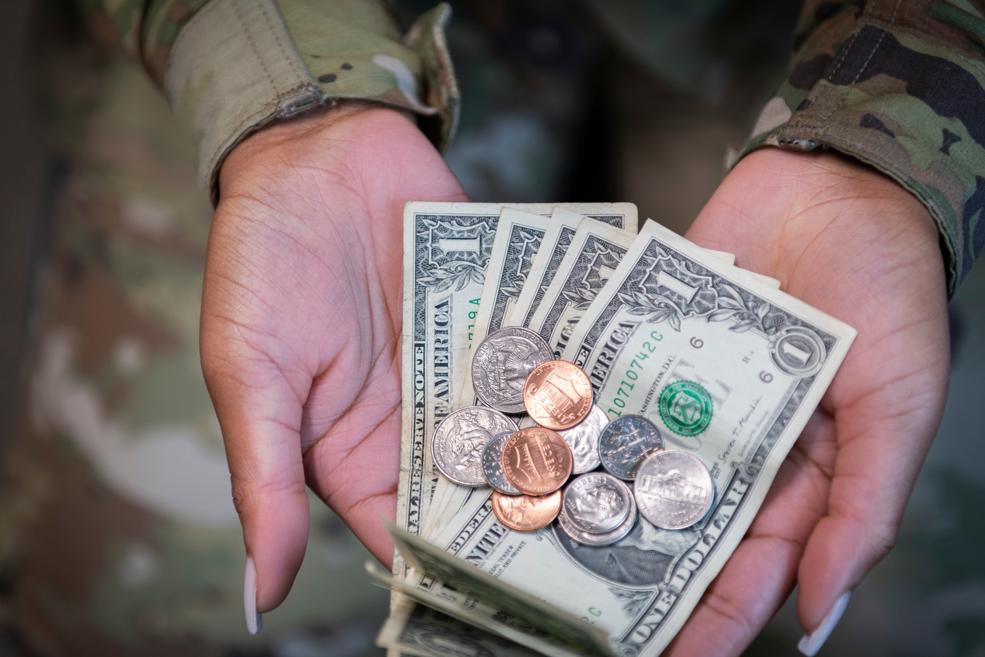 Photo of an Airman holding money