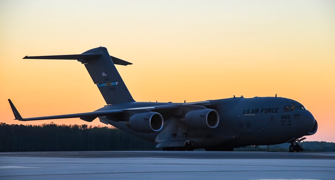 The sun rises over a C-17 Globemaster III aircraft on the flight line at Dover Air Force Base, Delaware, April 23, 2021. The C-17 Globemaster III is the most flexible cargo aircraft to enter the airlift force. The aircraft can perform tactical airlift and airdrop missions and transport litters of ambulatory patients during aeromedical evacuations. (U.S. Air Force photo by Airman 1st Class Stephani Barge)