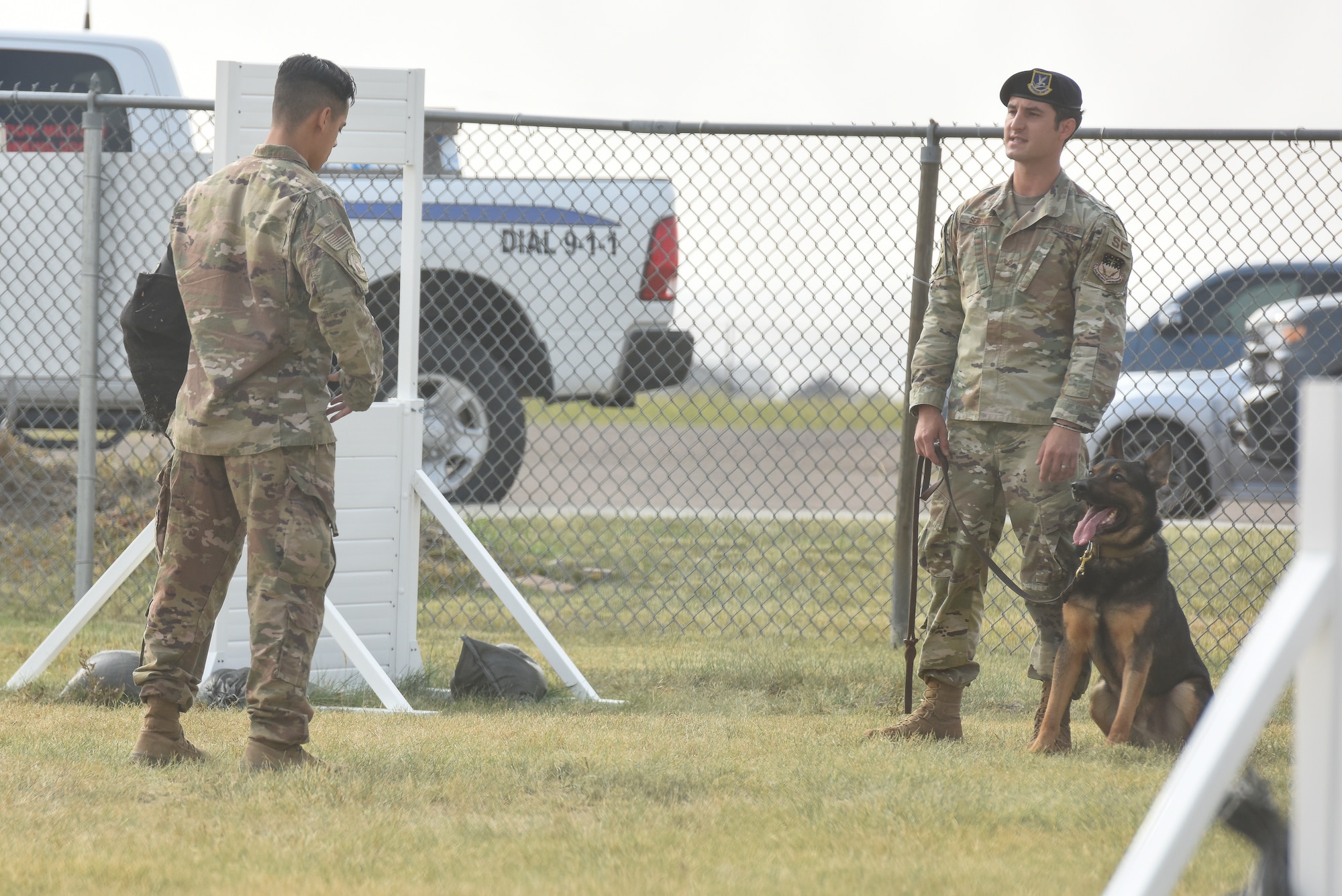 Senior Airman Dustin Sullivan, left, 341st Security Forces Squadron MWD handler, Staff Sgt. Zachary Seroogy, 341st SFS MWD handler, and MWD Paul, practice bite training Aug. 20, 2020, at Malmstrom Air Force Base, Mont.