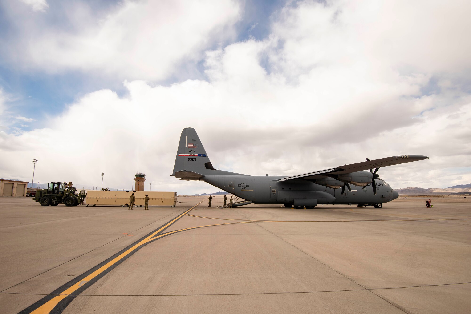 Airmen use a two ton fork lift puts an MQ-9 Reaper onto a C-130 for transport.