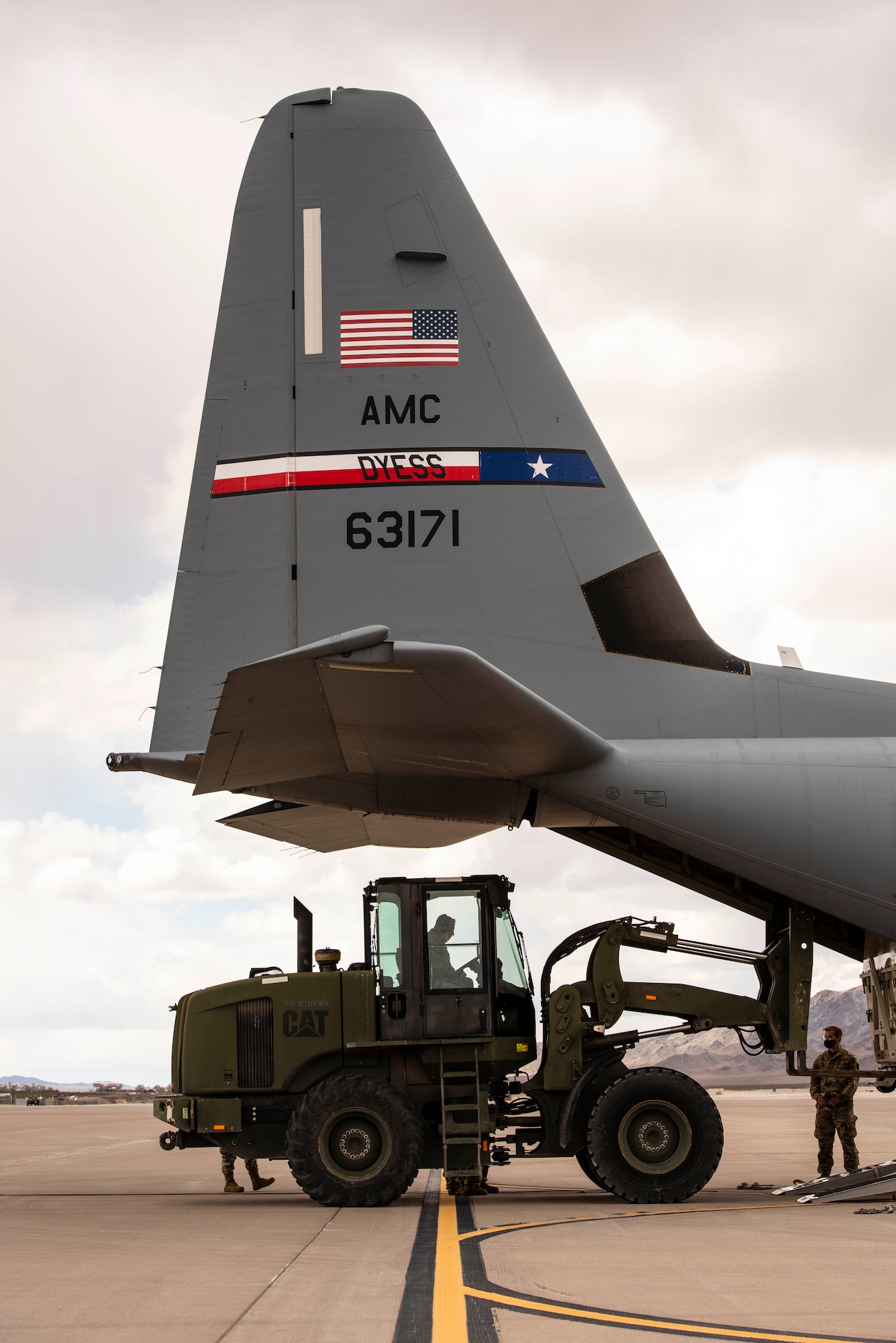 Airmen use a two ton fork lift puts an MQ-9 Reaper onto a C-130 for transport.