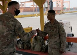 Army Reserve Brig. Gen. Justin M. Swanson, the deputy commanding general of the 1st Theater Sustainment Command, fist pumps Spc. Demarcus Russ after the general's April 24, 2021 tour of port operation at Kuwait's Port Shuaiba. The general was thanking Soldiers for providing security during offload and onload operations, when the New Orleans native learned that the specialist with the 1st Armored Division Soldier grew up in Jonesville, Louisiana.