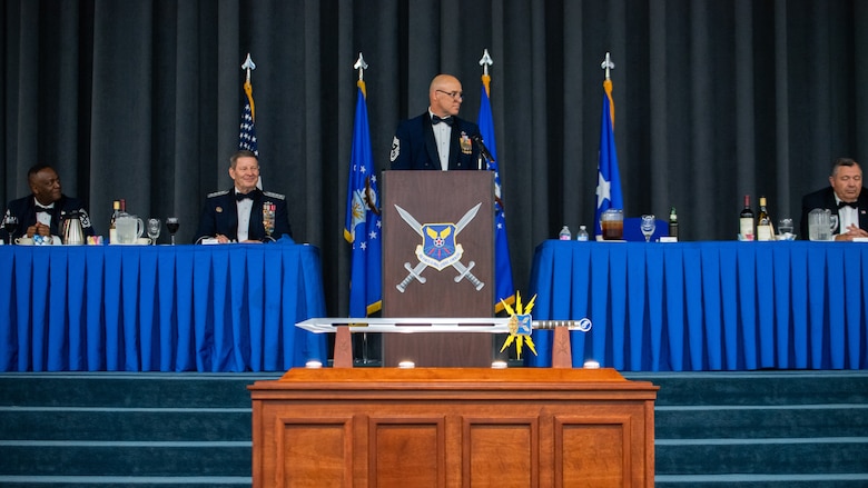 Chief Master Sgt. Robert Tibi, center, Air Force Global Strike Command command first sergeant, makes remarks during the Order of the Sword ceremony honoring retired Gen. Robin Rand, second from left, former AFGSC commander, at Barksdale Air Force Base, Louisiana, April 23, 2021. The Order of the Sword ceremony was patterned after two orders of chivalry founded during the Middle Ages in Europe: the (British) Royal Order of the Sword and the Swedish Military Order of the Sword, still in existence today. (U.S. Air Force photo by Airman 1st Class Jacob B. Wrightsman)