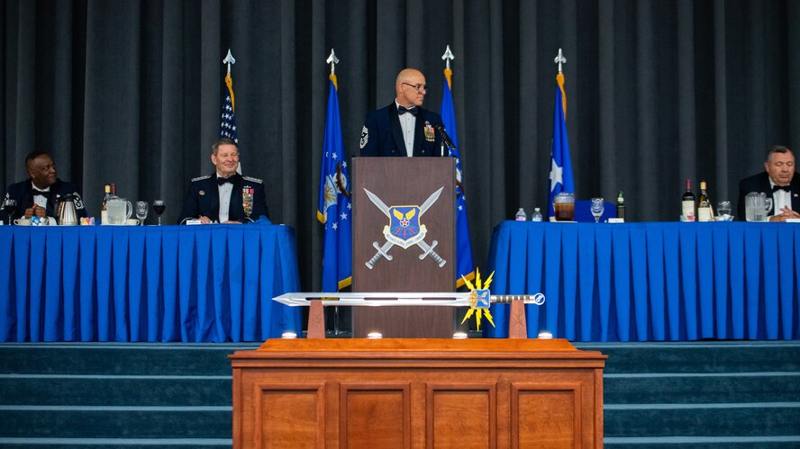 Chief Master Sgt. Robert Tibi, center, Air Force Global Strike Command command first sergeant, makes remarks during the Order of the Sword ceremony honoring retired Gen. Robin Rand, second from left, former AFGSC commander, at Barksdale Air Force Base, Louisiana, April 23, 2021. The Order of the Sword ceremony was patterned after two orders of chivalry founded during the Middle Ages in Europe: the (British) Royal Order of the Sword and the Swedish Military Order of the Sword, still in existence today. (U.S. Air Force photo by Airman 1st Class Jacob B. Wrightsman)