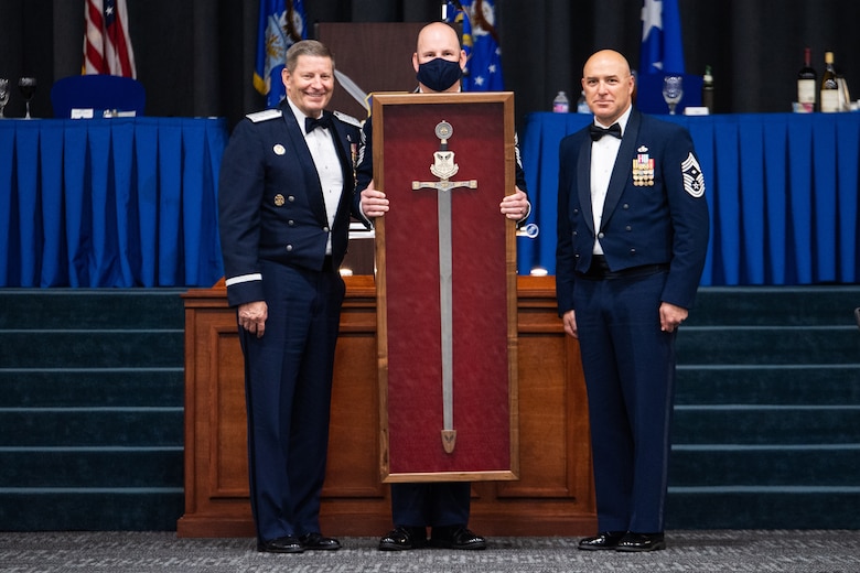 Chief Master Sgt. Robert Tibi, right, Air Force Global Strike Command command first sergeant, presents the Order of the Sword to retired Gen. Robin Rand, left, former AFGSC commander, at Barksdale Air Force Base, Louisiana, April 23, 2021. The Order of the Sword is an Air Force tradition in which members of the enlisted corps recognize and honor senior officers and civilians who have made significant contributions to the welfare and prestige of the enlisted corps. (U.S. Air Force photo by Airman 1st Class Jacob B. Wrightsman)