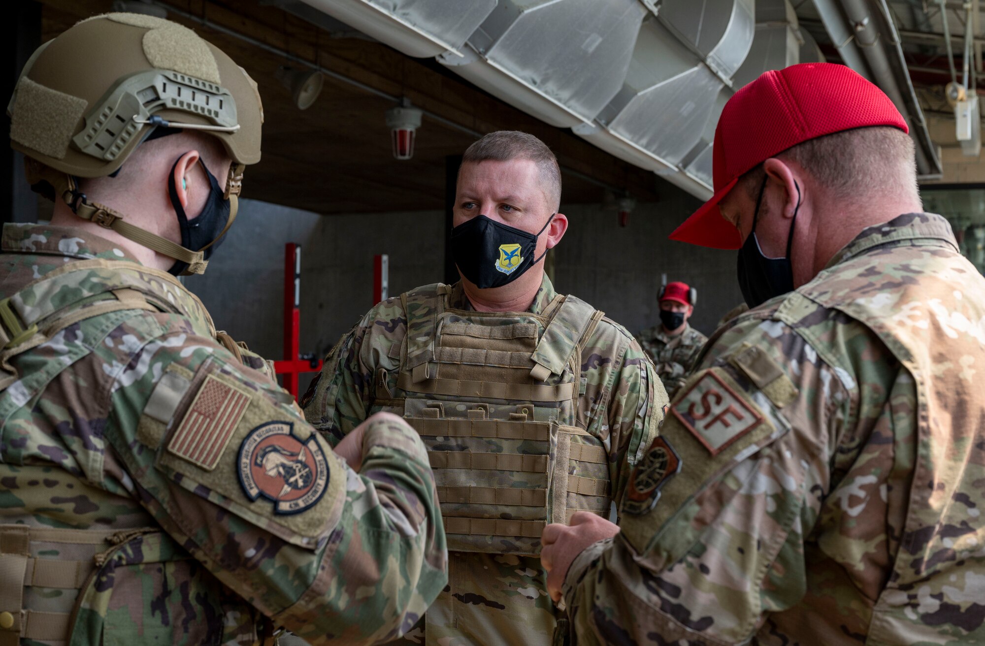 Col. Matthew Jones, 436th Airlift Wing commander, center, speaks with Capt. Michael Brickell, 436th Security Forces Squadron operations officer, left, and Tech. Sgt. Joseph Haller, 436th SFS noncommissioned officer in charge of Combat Arms Training and Maintenance, right, about the proper wear of safety gear at Dover Air Force Base, Delaware, April 27, 2021. The CATM facility is where service members receive training and qualify on various types of weapons. (U.S. Air Force photo by Airman 1st Class Cydney Lee)