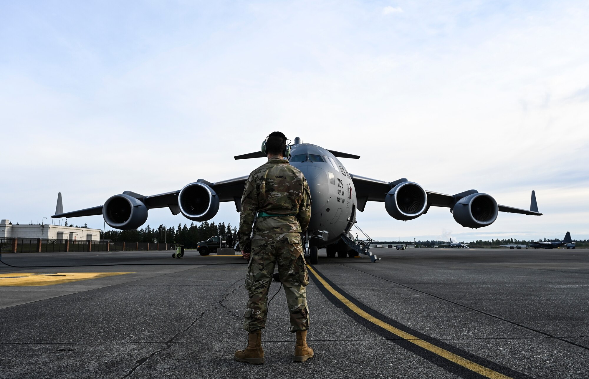 U.S. Air Force Senior Airman Gustavo Burciaga, 62nd Aircraft Maintenance Squadron crew chief, communicates with the pilots on a C-17 Globemaster III in preparation for an airlift mission as part of Exercise Rainier War at Joint Base Lewis-McChord, Washington, April 28, 2021. Rainier War tests the 62nd Airlift Wing's capability to plan, generate and execute a deployment tasking, sustain contingency operations, demonstrate full spectrum readiness while executing agile combat employment in a contested, degraded and operationally limited environment. (U.S. Air Force photo by Master Sgt. Julius Delos Reyes)