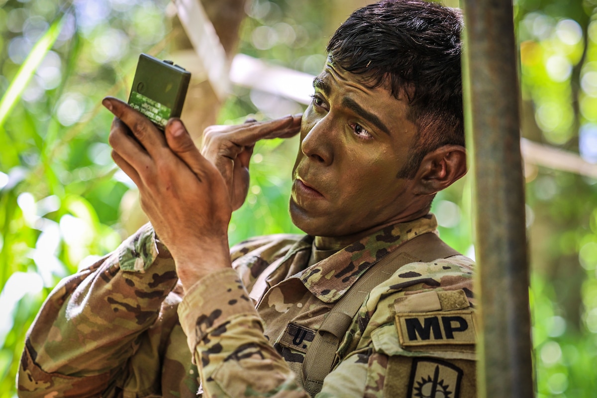A soldier puts on camouflage makeup.