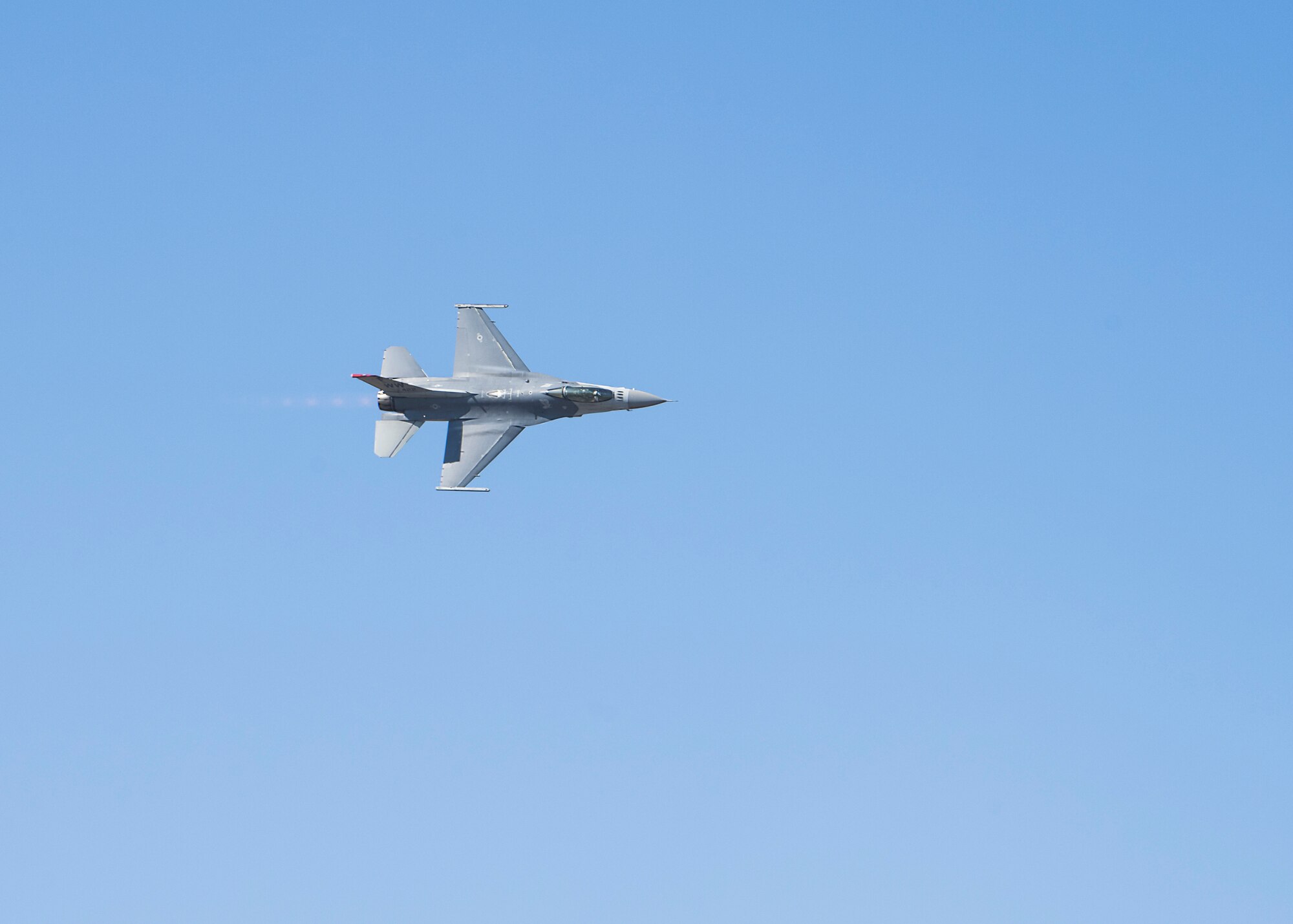 A F-16 flying above Misawa Air Base performing aerial maneuvers.