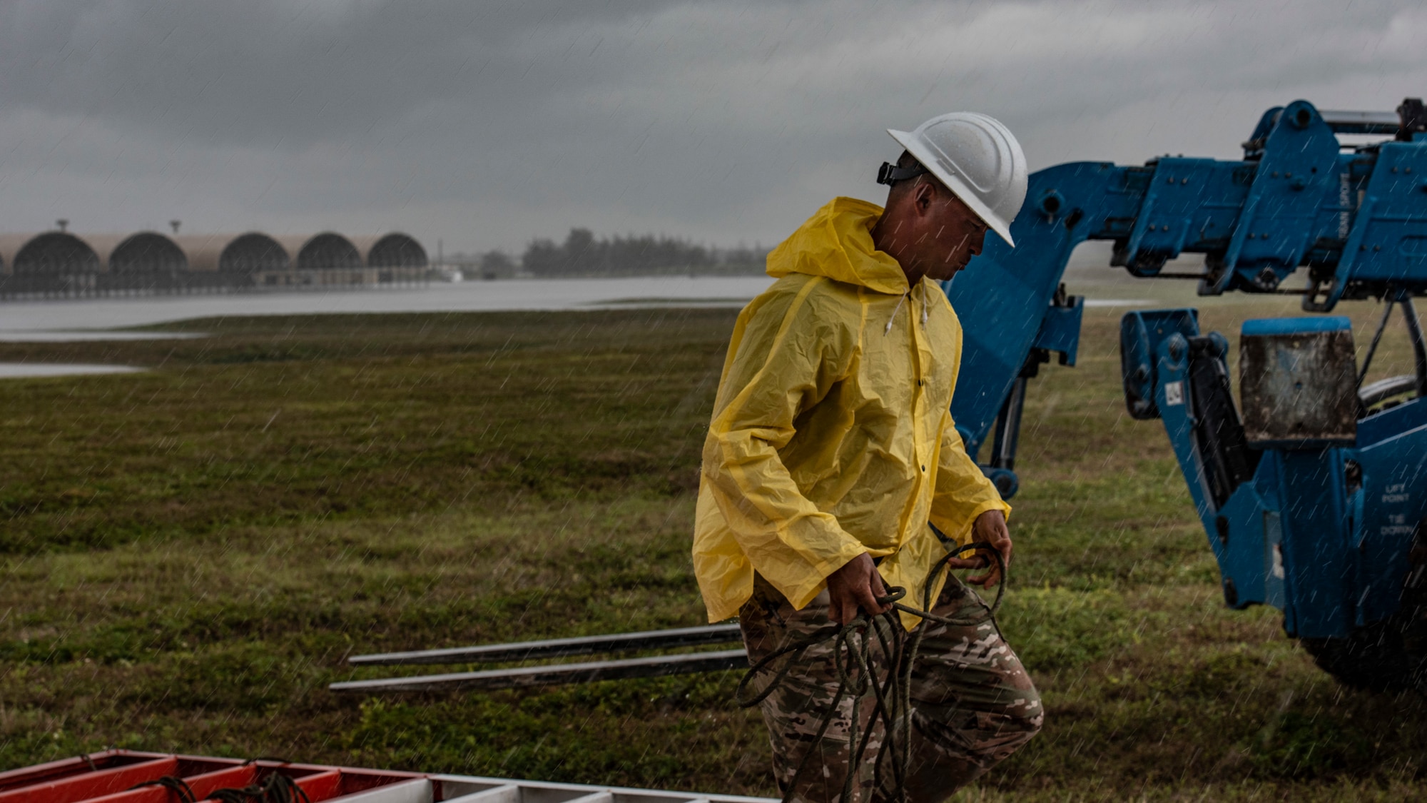 U.S. Air Force Master Sgt. Jeremy Lawson, 36th Civil Engineer Squadron heavy repair section chief, carries a trail line in the rain on Andersen Air Force Base, Guam, April 26, 2021.