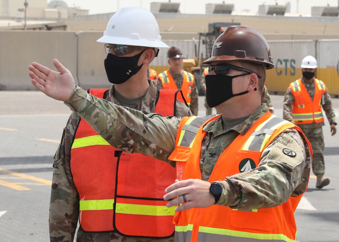 Col. Michael Ludwick, commander of 595th Transportation Brigade (SDDC), gestures while he describes port operations to Brig. Gen. Justin M. Swanson, the deputy commanding general of the 1st Theater Sustainment Command, while on Swanson's April 24, 2021 tour of Kuwait's Port Shuaiba. The 595th TB (SDDC) integrates and synchronizes surface deployment and distribution capabilities to project readiness and sustain the warfighter throughout the U.S. Central Command area of operations.