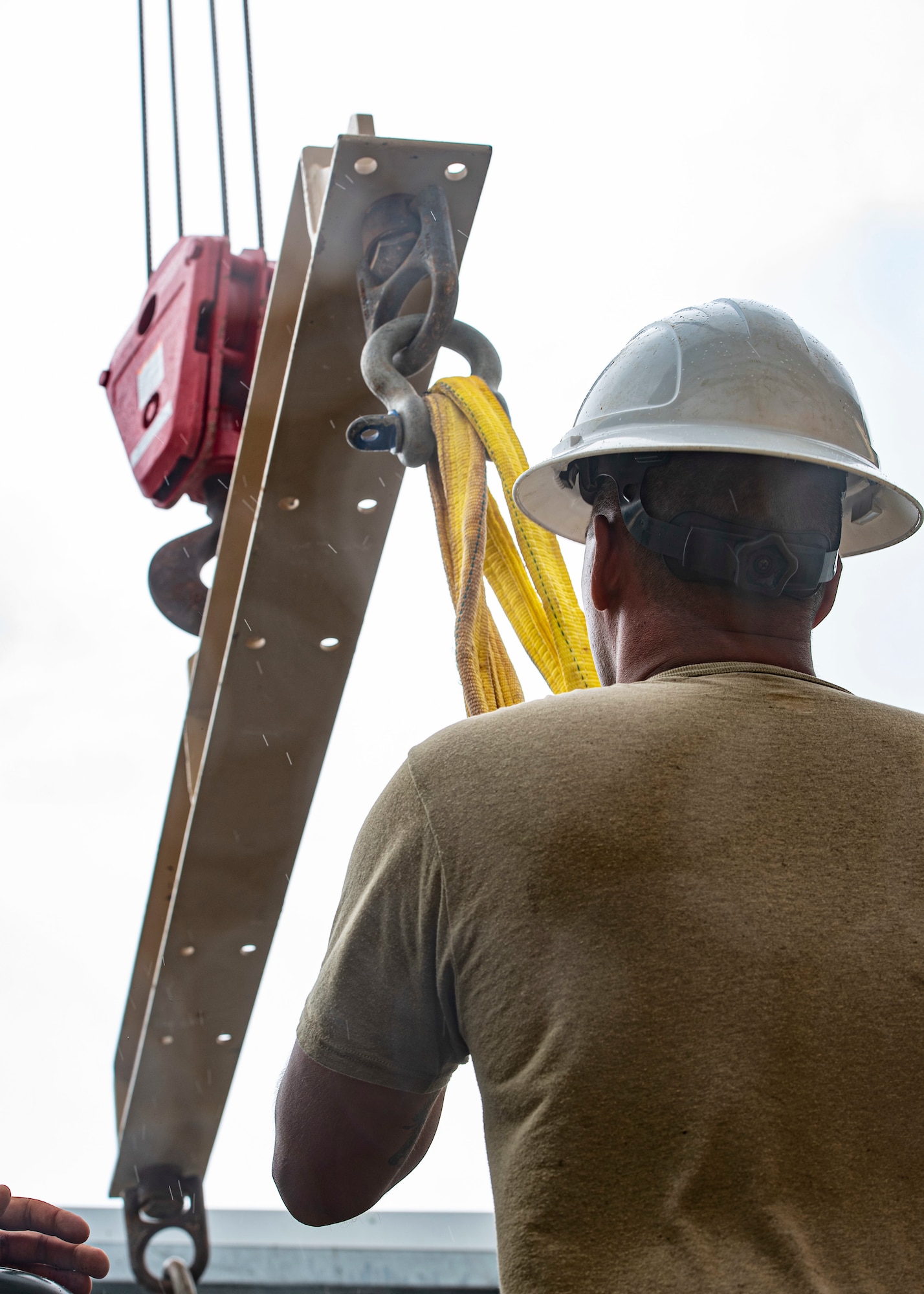 U.S. Air Force Master Sgt. Jeremy Lawson, 36th Civil Engineer Squadron heavy repair section chief, attaches the new Barrier Arresting Kit to a crane to be hoisted into place at Andersen Air Force Base, Guam, April 26, 2021.