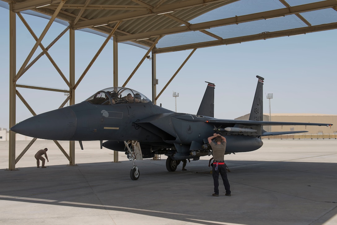 A crew chief assigned to the 380th Expeditionary Aircraft Maintenance Squadron marshals an F-15E Strike Eagle assigned to the 332nd Air Expeditionary Wing (AEW) at Al Dhafra Air Base, United Arab Emirates, April 25, 2021.