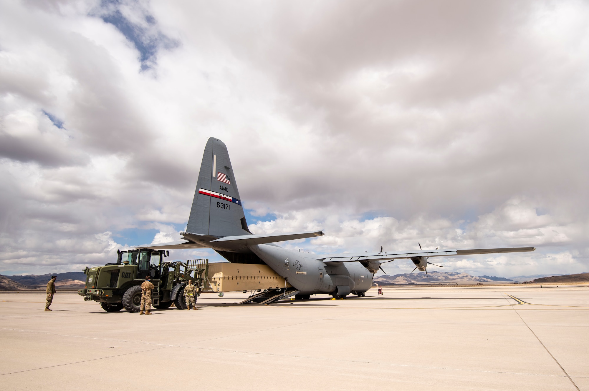 Airmen use a two ton fork lift puts an MQ-9 Reaper onto a C-130 for transport.