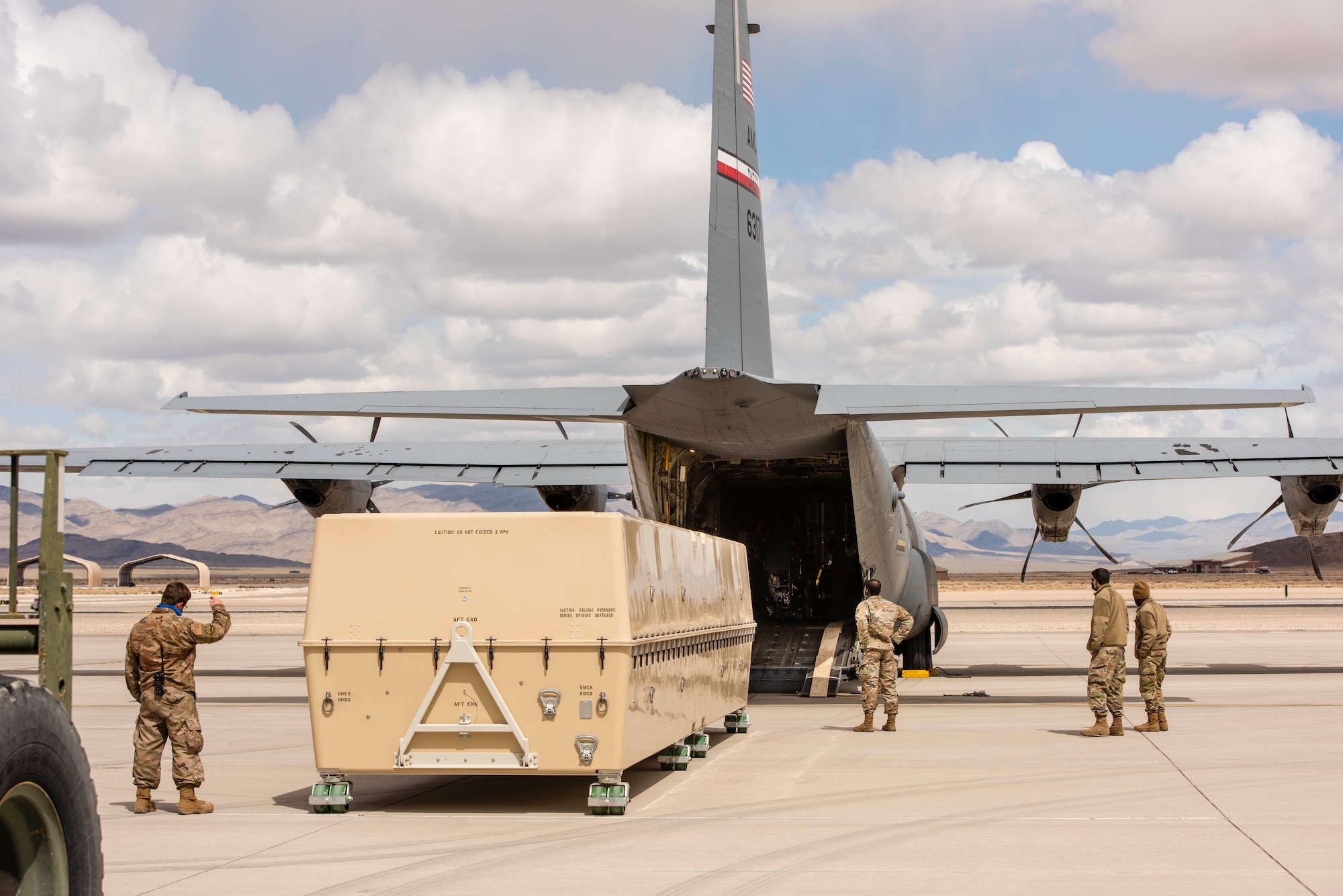 Airmen use a two ton fork lift puts an MQ-9 Reaper onto a C-130 for transport.