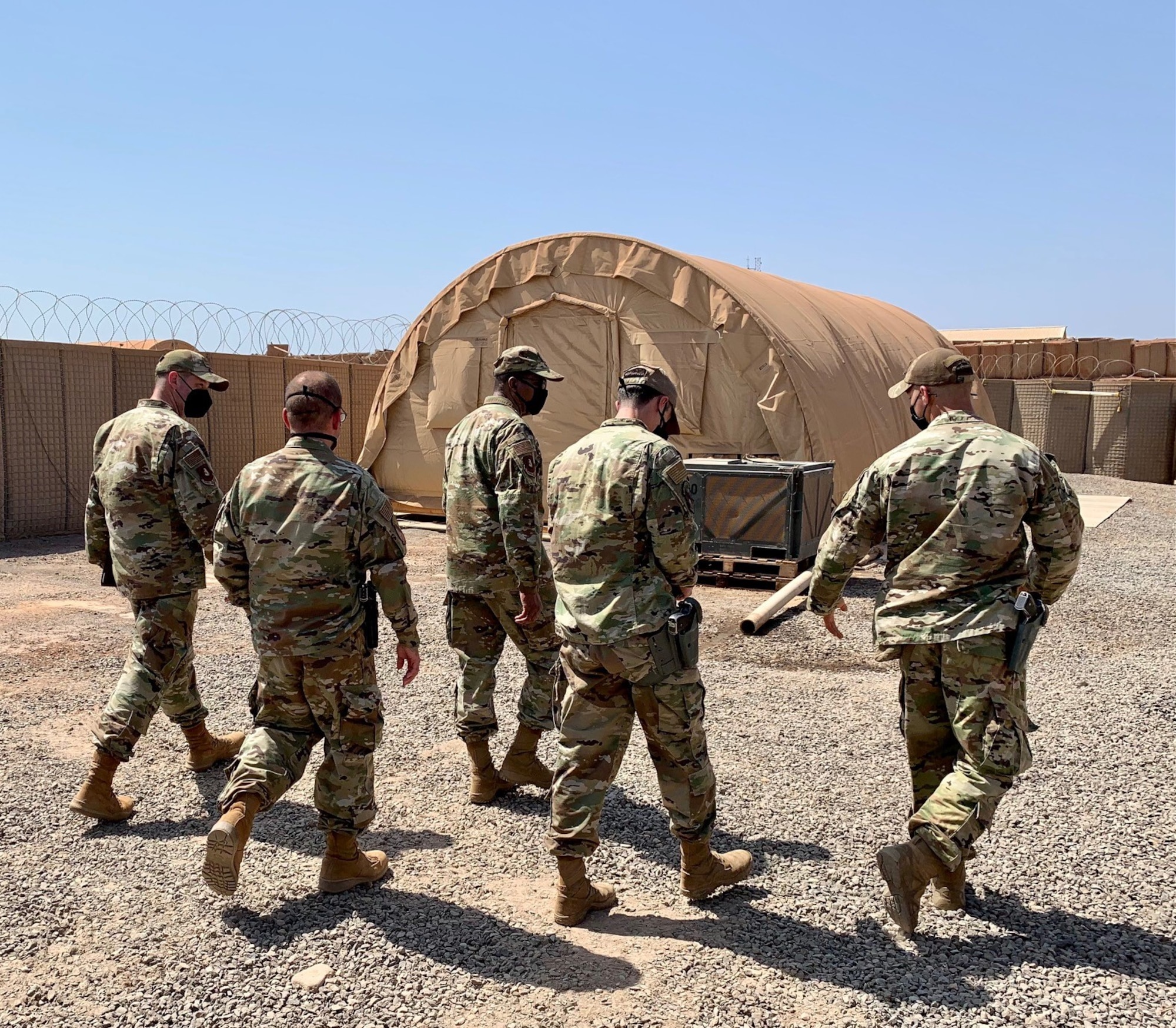 U.S. Air Force Staff Sergeants Dakota Farrow and Patrick Saddoris, 726th Expeditionary Air Base squadron military working dog handlers, walk with Maj. Gen. Randall Reed, Third Air Force commander and Chief Master Sergeant Randy Kwiatkowski, Third Air Force command chief, at Camp Chabelley, Djibouti, April 15, 2021. Farrow and his MWD, Max, are deployed from the 56th Security Forces Squadron at Luke AFB, Arizona, while Saddoris and Benny are from the 9th SFS at Beale AFB, California. (Courtesy photo by Maj. Tim O’Rouke)